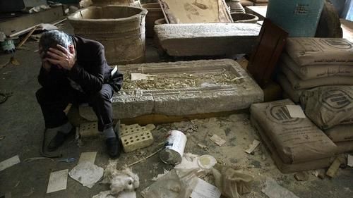 Замдиректора Национального музея Ирака Мушин Хасан обхватил голову руками, сидя на разбитых артефактах в Багдаде. Музей был сильно разграблен. Апрель 2003 г.